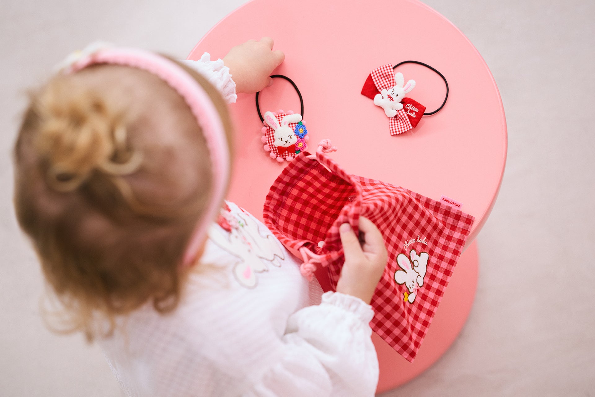 チエコサクアクセサリーを巾着袋にしまう女の子